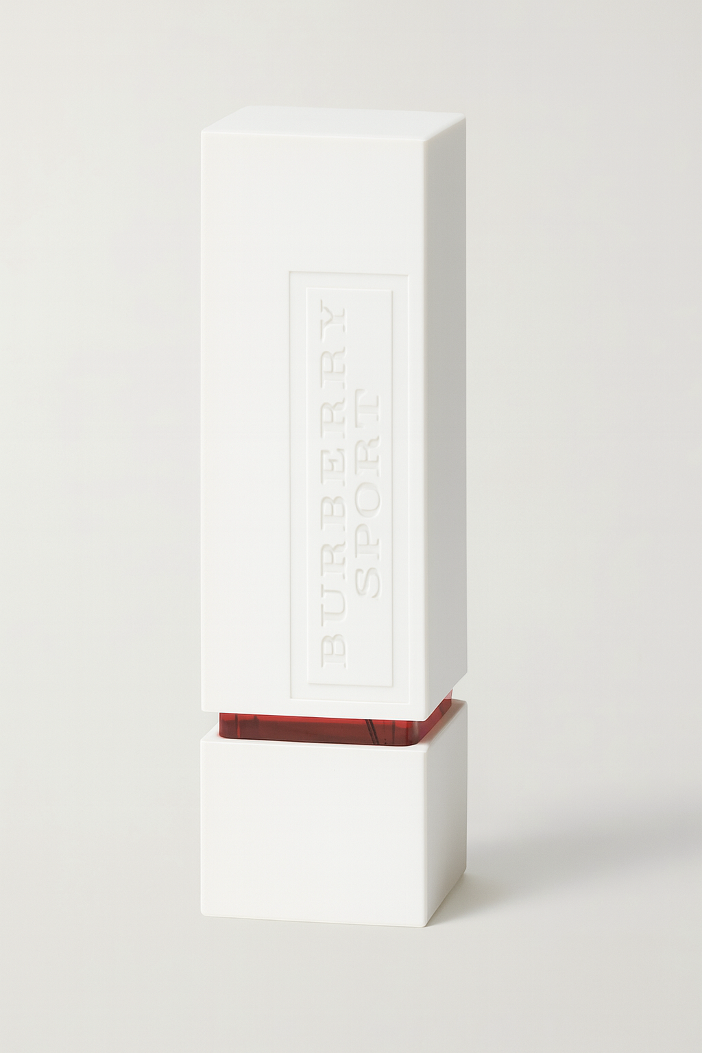 Schräg fotografiertes, rechteckiges Parfumflakon von Burberry Sport mit weißer Hülle und geprägtem Logo, roter Glasunterseite und neutralem Hintergrund.