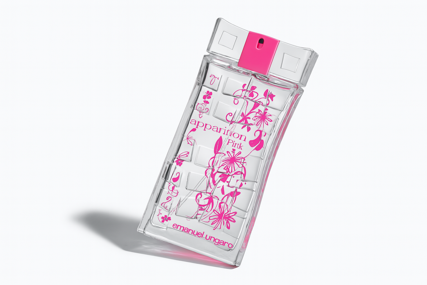 Ein transparentes rechteckiges Parfumflakon von Emanuel Ungaro "Apparition Pink", leicht nach rechts gekippt. Die Flasche zeigt pinke florale Verzierungen und eine klare Vorderaufschrift. Der Hintergrund ist neutral und der Flakon wirft einen weichen Schatten.