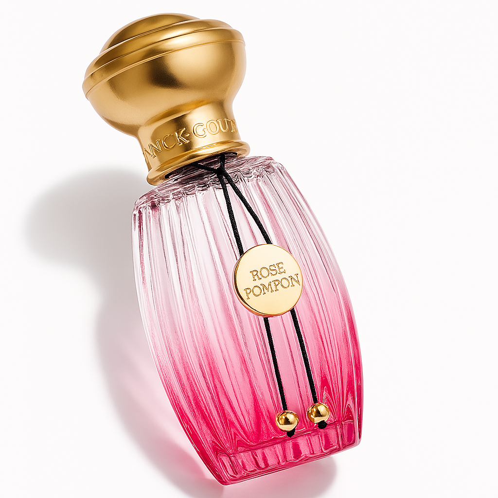 Ein leicht seitlich geneigtes, rosafarbenes Parfümflakon mit goldener Kappe und einem goldenen Anhänger mit der Aufschrift „ROSE POMPON“. Das Glas ist gerippt und verläuft farblich von transparent zu kräftigem Pink. Ein weicher Schatten wird auf den weißen Hintergrund geworfen.