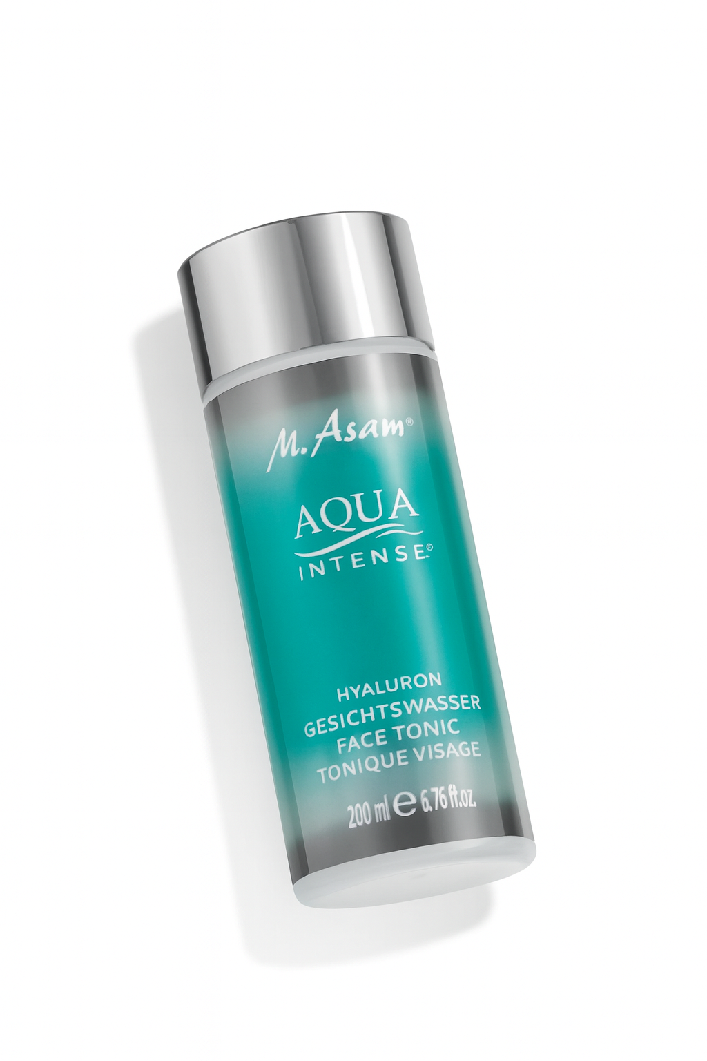 Eine zylindrische Flasche des M. Asam Aqua Intense Hyaluron Gesichtswassers liegt leicht schräg auf einem weißen Hintergrund. Die Flasche ist türkis mit silbernem Deckel, die Beschriftung gut lesbar, und sie wirft einen weichen Schatten.