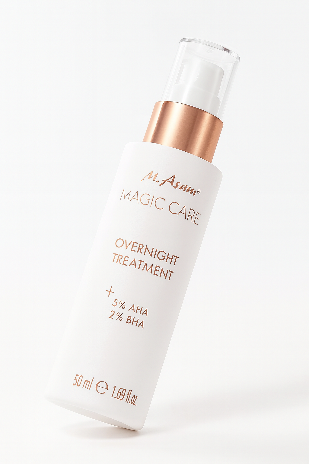 Eine weiße Pumpflasche der M. Asam Magic Care Overnight Treatment liegt leicht nach hinten geneigt auf einem neutralen Hintergrund. Der roségoldene Pumpkopf kontrastiert elegant mit dem weißen Flaschenkörper, auf dem die kupferfarbene Schrift mit Produktnamen und Inhaltsangaben gut lesbar ist. Ein sanfter Schatten verstärkt die Tiefe und Perspektive.