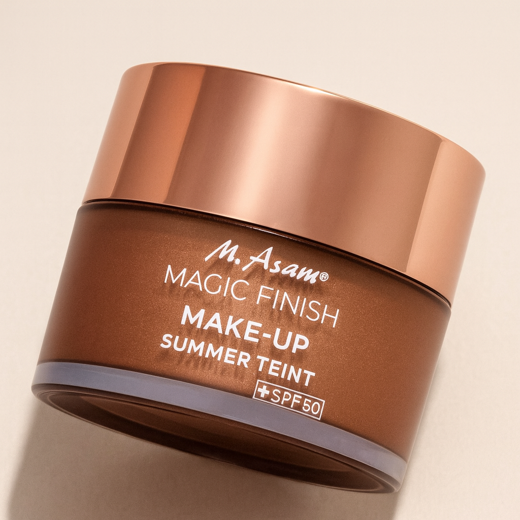 Ein kupferfarbener Tiegel der M. Asam Magic Finish Make-Up Summer Teint SPF 30 liegt leicht nach hinten geneigt auf einem neutralen Hintergrund. Der glänzende roségoldene Deckel reflektiert das Licht, während der bronzefarbene Behälter mit weißer Aufschrift klar sichtbar ist. Ein weicher Schatten verstärkt die Tiefe und Perspektive.