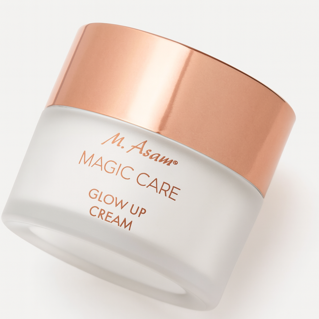 Eine Glasdose der M. Asam Magic Care Glow Up Cream liegt leicht nach hinten geneigt auf einem neutralen Hintergrund. Der mattierte Glaskörper trägt eine roségoldene Aufschrift, der glänzende Deckel in Roségold reflektiert sanft das Licht. Ein weicher Schatten betont die Tiefe und Perspektive.