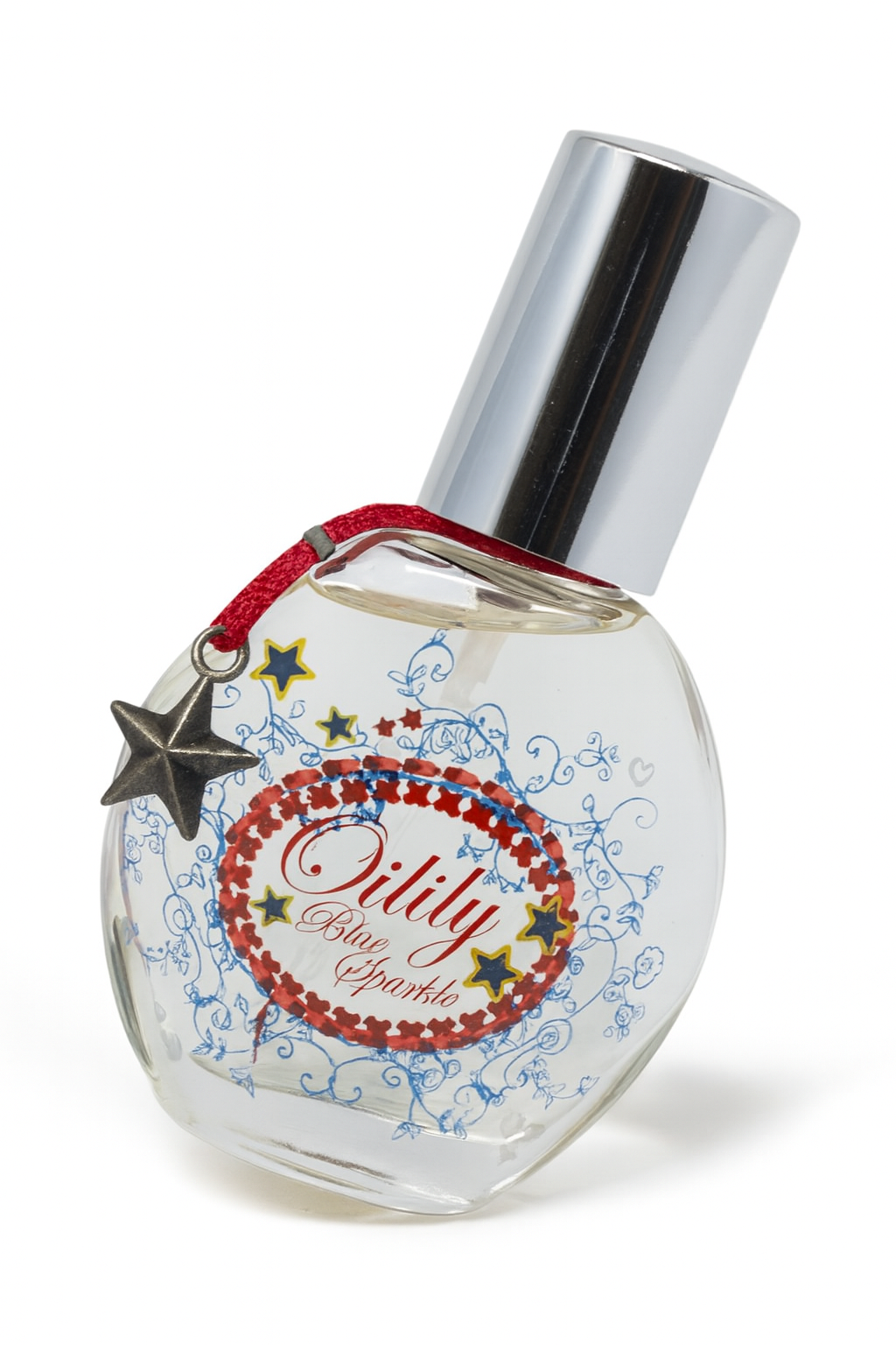 Ein rundes, transparentes Parfumflakon von Oilily Blue Sparkle, das leicht zur Seite gekippt steht. Es hat eine silberne Kappe, ein verspieltes Etikett in Rot, Blau und Gold sowie ein kleines rotes Bändchen mit einem Sternanhänger. Das Flakon wirft einen natürlichen, weichen Schatten auf neutralem Hintergrund.