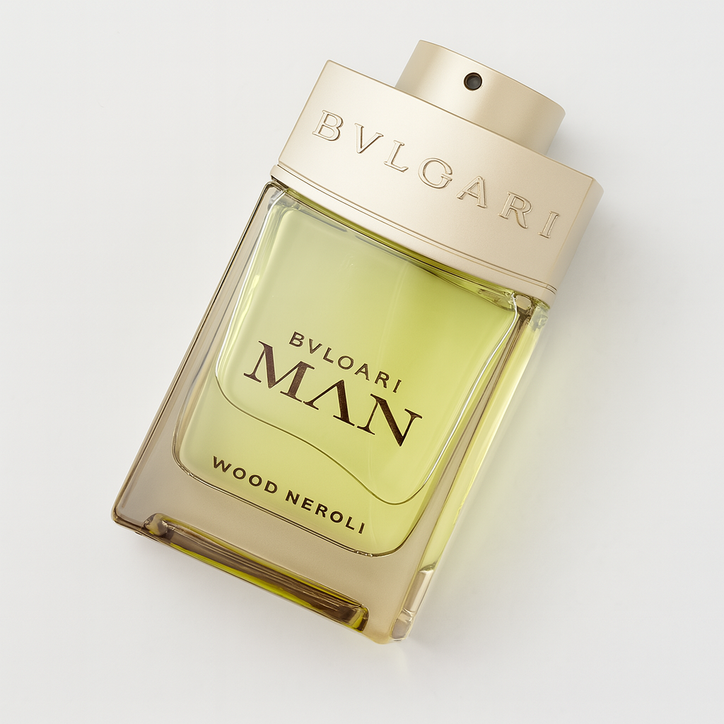 Schräg liegendes Bvlgari MAN Wood Neroli Eau de Parfum in einem transparenten Glasflakon mit goldfarbenem Deckel und grüngelbem Inhalt vor neutralem Hintergrund. Ein weicher Schatten verleiht Tiefe.