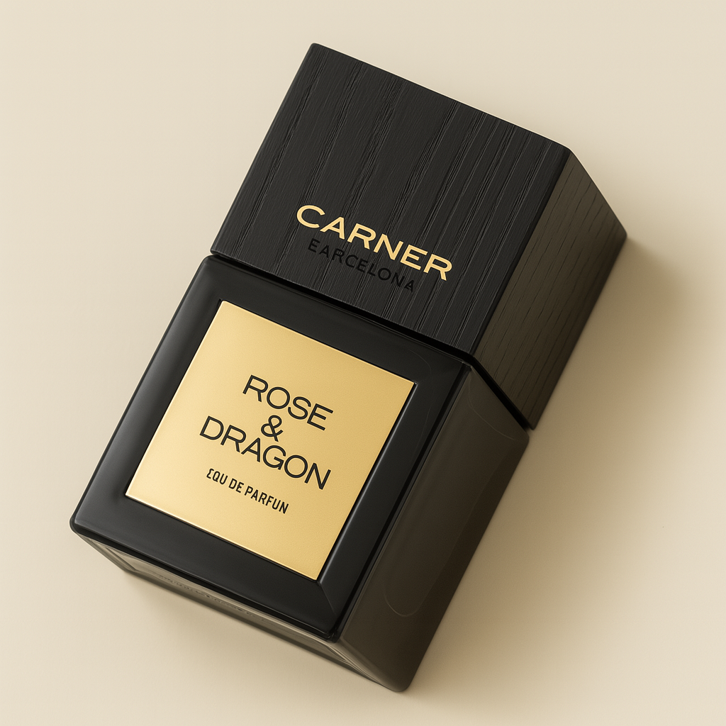 Ein eckiger, seitlich geneigter schwarzer Flakon des Parfums „Rose & Dragon“ von Carner Barcelona liegt auf einem neutralen, beigefarbenen Hintergrund. Die Vorderseite zeigt ein goldfarbenes Etikett mit schwarzer Aufschrift. Der Verschluss ist ebenfalls eckig, schwarz und wirkt wie aus Holz mit feiner Maserung. Ein weicher Schatten umgibt das edle Design.