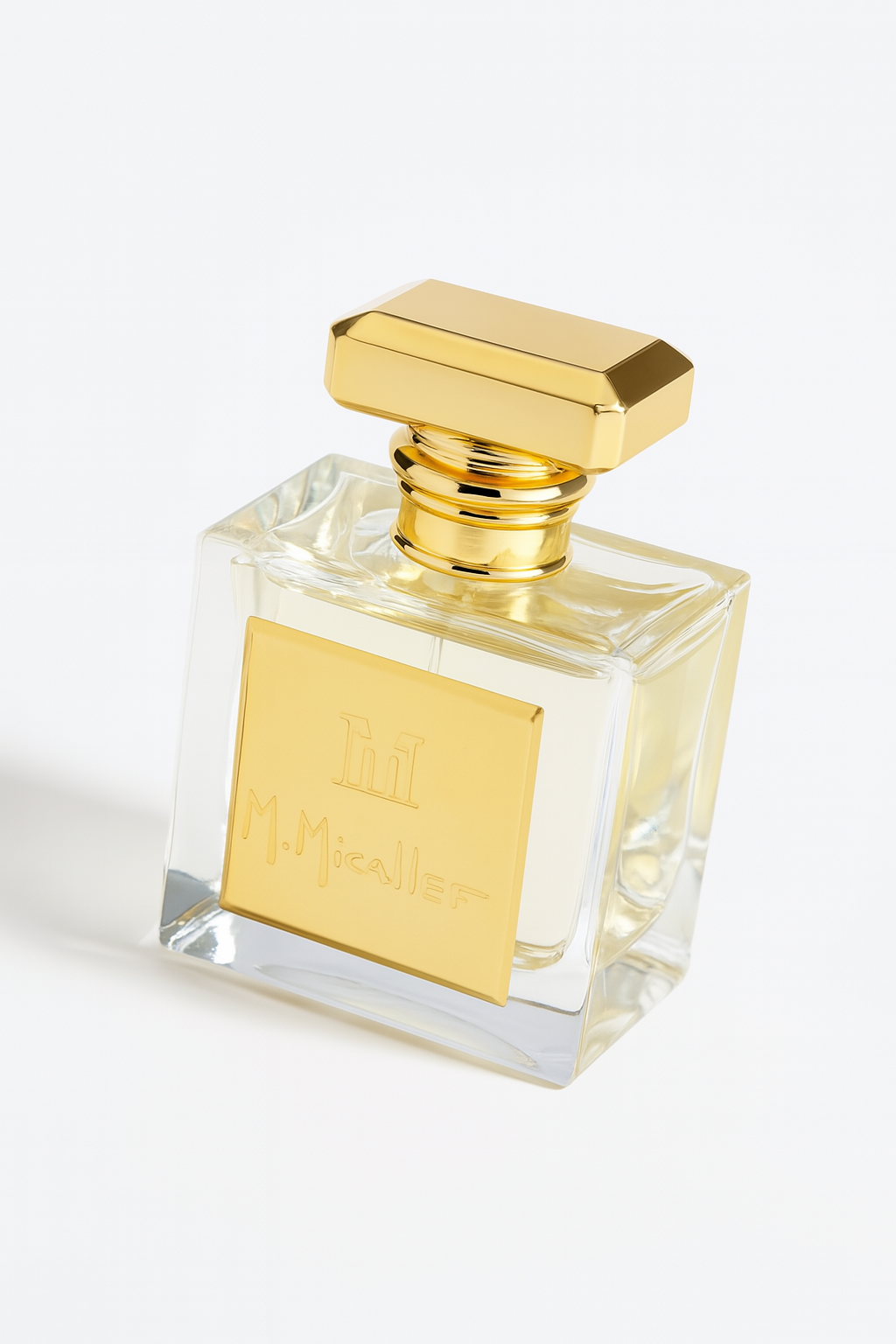 Ein quadratisches, transparentes Parfumflakon von M. Micallef mit goldenem Logo und passendem goldfarbenem Verschluss. Das Flakon ist leicht nach hinten gekippt und steht auf einem neutralen weißen Hintergrund, mit einem sanften Schatten für mehr Tiefe.