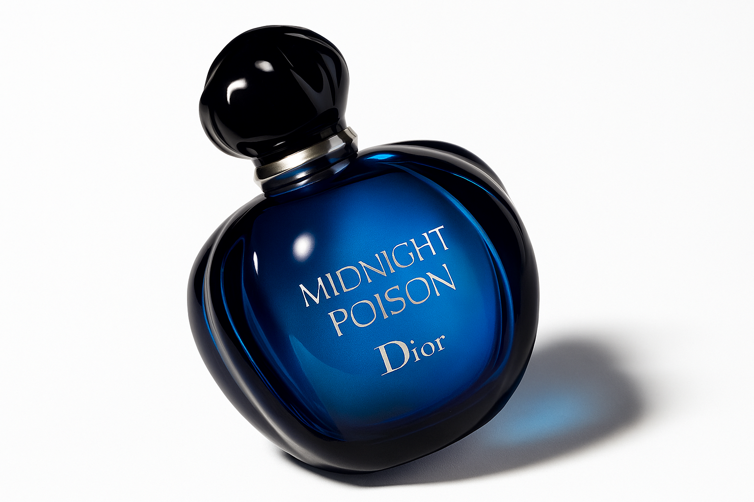 Ein schräg nach hinten geneigtes, tiefblaues Parfumflakon mit dem silbernen Aufdruck „MIDNIGHT POISON Dior“. Das Flakon steht auf einem neutralen, hellen Untergrund und wirft einen weichen, natürlichen Schatten. Die glänzende Oberfläche reflektiert Licht sanft, der schwarze Verschluss kontrastiert elegant mit dem blauen Glas.