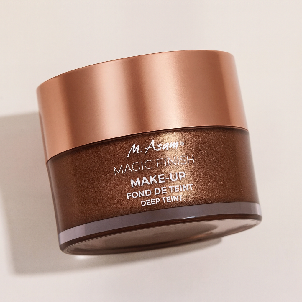 Ein rundes Make-up-Tiegelchen der M. Asam Magic Finish Make-Up Mousse Deep Teint liegt leicht nach hinten geneigt auf einem neutralen Hintergrund. Der glänzende roségoldene Deckel reflektiert sanft das Licht, während der dunkelbraune Körper mit weißer Aufschrift gut sichtbar ist. Ein weicher Schatten unterstreicht die Tiefe und Perspektive.