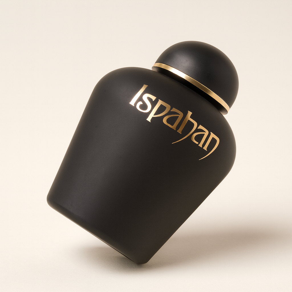 Ein schräg nach hinten geneigtes, matt schwarzes Parfumflakon mit goldfarbener Aufschrift „Ispahan“ vor neutralem, hellem Hintergrund. Der runde Verschluss ist ebenfalls schwarz mit einem goldenen Zierband. Ein weicher Schatten fällt nach hinten rechts.