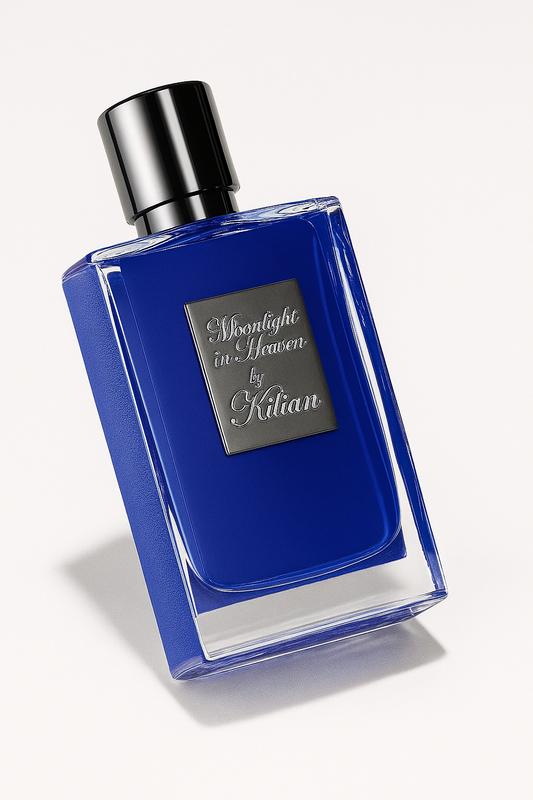 Eine schräg platzierte, tiefblaue Parfumflasche von "Moonlight in Heaven by Kilian" mit silberner Verschlusskappe und silbernem Etikett, vor neutralem weißem Hintergrund. Die Flasche wirft einen weichen Schatten.