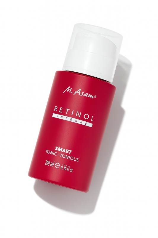Eine rote Pumpflasche des M. Asam Retinol Intense Smart Tonic liegt leicht nach hinten geneigt auf einem weißen Hintergrund. Die weiße Schrift mit Produktnamen und Details ist klar erkennbar, während der weiße Pumpdeckel elegant kontrastiert. Ein sanfter Schatten sorgt für Tiefe und Perspektive.