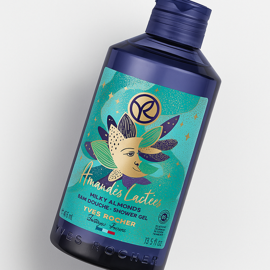 Eine durchsichtige, blaue Kunststoffflasche mit Verschlusskappe, leicht nach rechts gekippt, steht auf neutralem Hintergrund. Auf der Vorderseite ist das Label von Yves Rocher Amandes Lactées / Milky Almonds Shower Gel mit dekorativem, goldenem Mandeldesign gut sichtbar. Ein weicher Schatten sorgt für Tiefe.